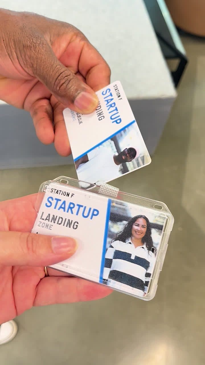 Deux badges Station F tenus dans une main
