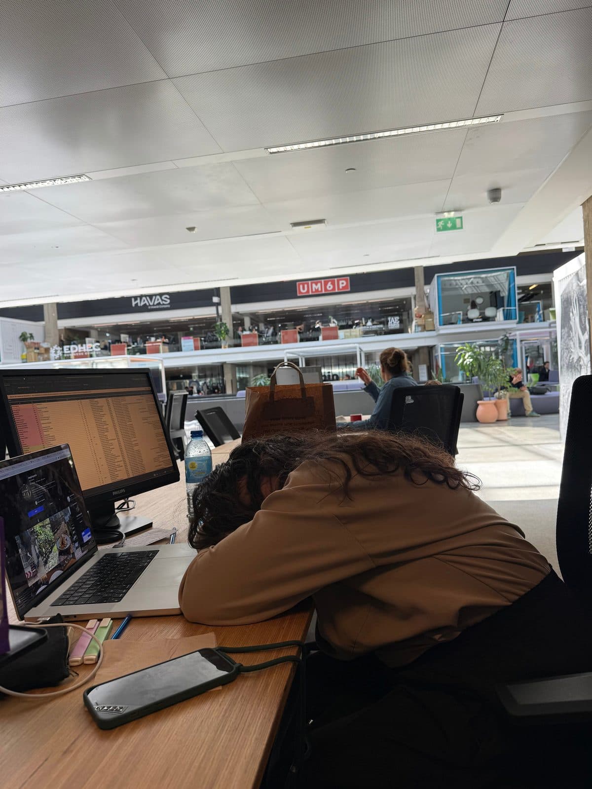 Amandine endormie sur son bureau devant ses écrans