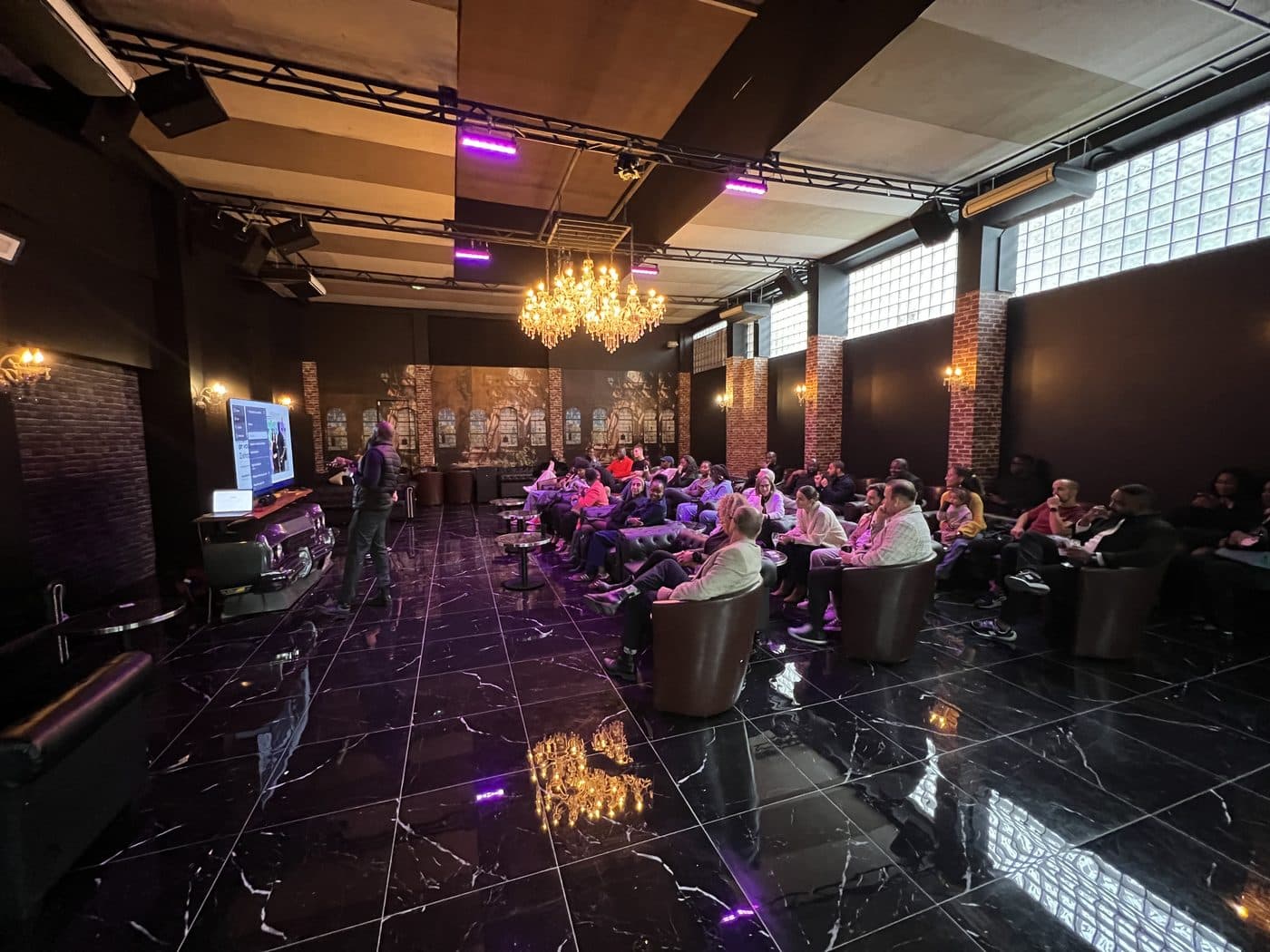La salle de réception, les invités installés sous les lustres
